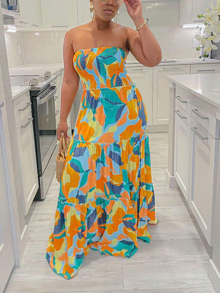 Woman in a multi-colored abstract print strapless maxi dress