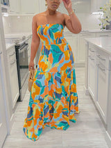 Woman in a multi-colored abstract print strapless maxi dress
