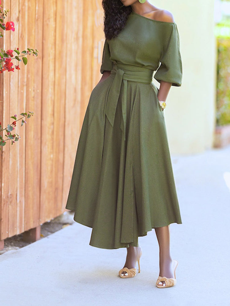 Woman posing in a stylish green midi dress