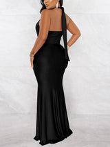 Back view of a woman in a long black mermaid dress with a halter tie