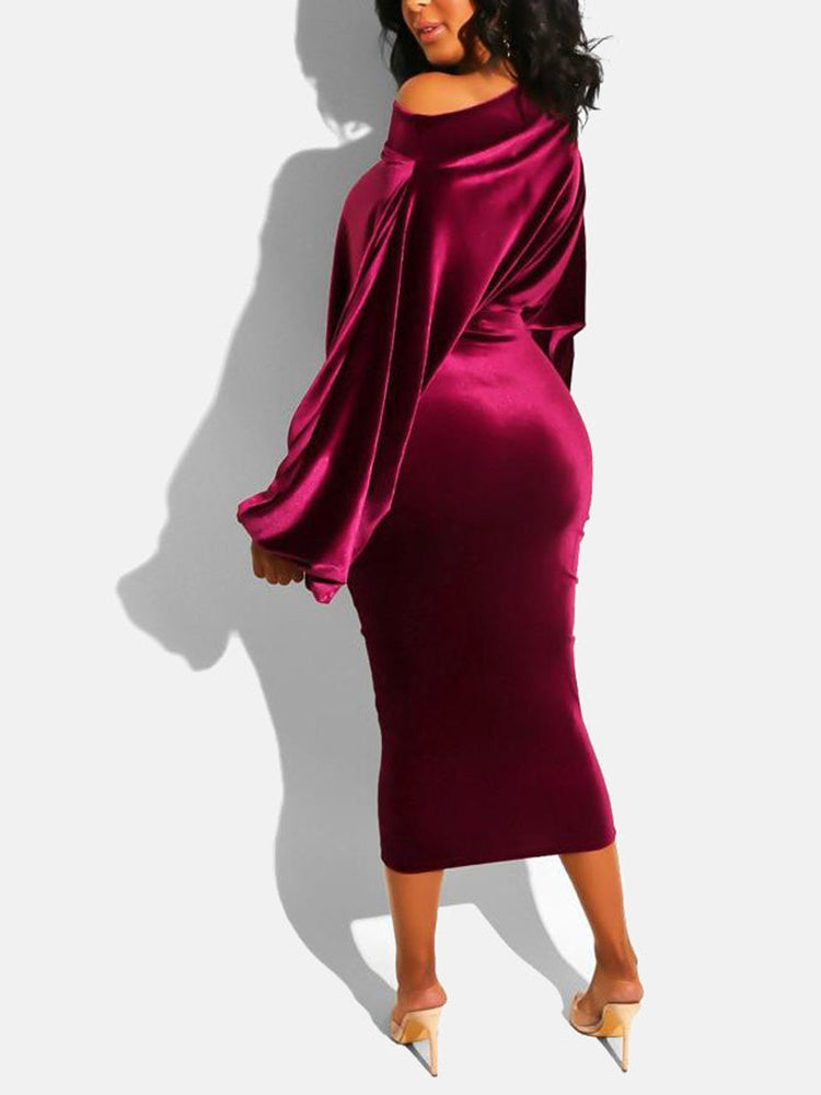 Rear view of a woman in a red velvet off-the-shoulder midi dress with long sleeves.