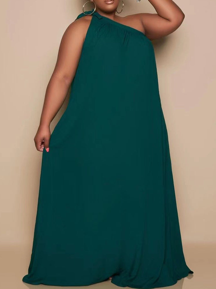 plus-size woman wearing a dark green one-shoulder maxi dress with pockets