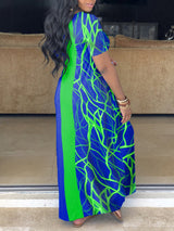 Side view of a woman wearing a blue and green color block maxi dress with an abstract graphic print.