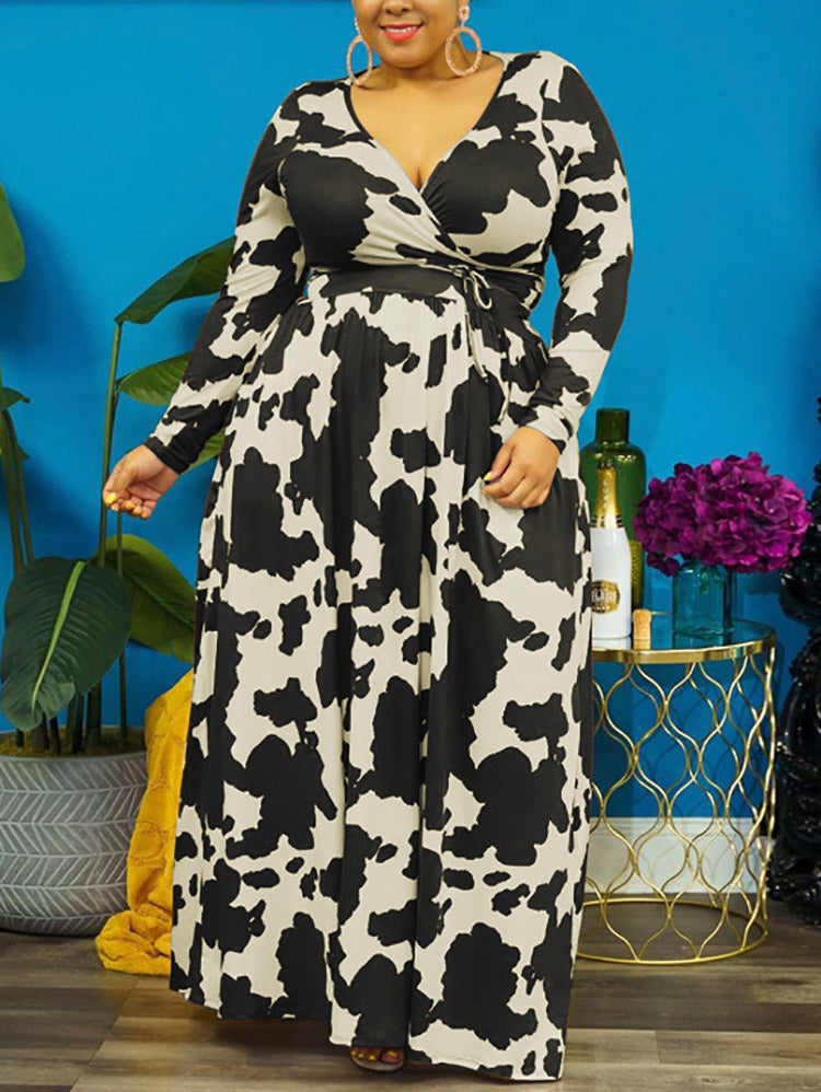 Woman wearing a black and white cow print maxi dress with long sleeves and a surplice neckline.