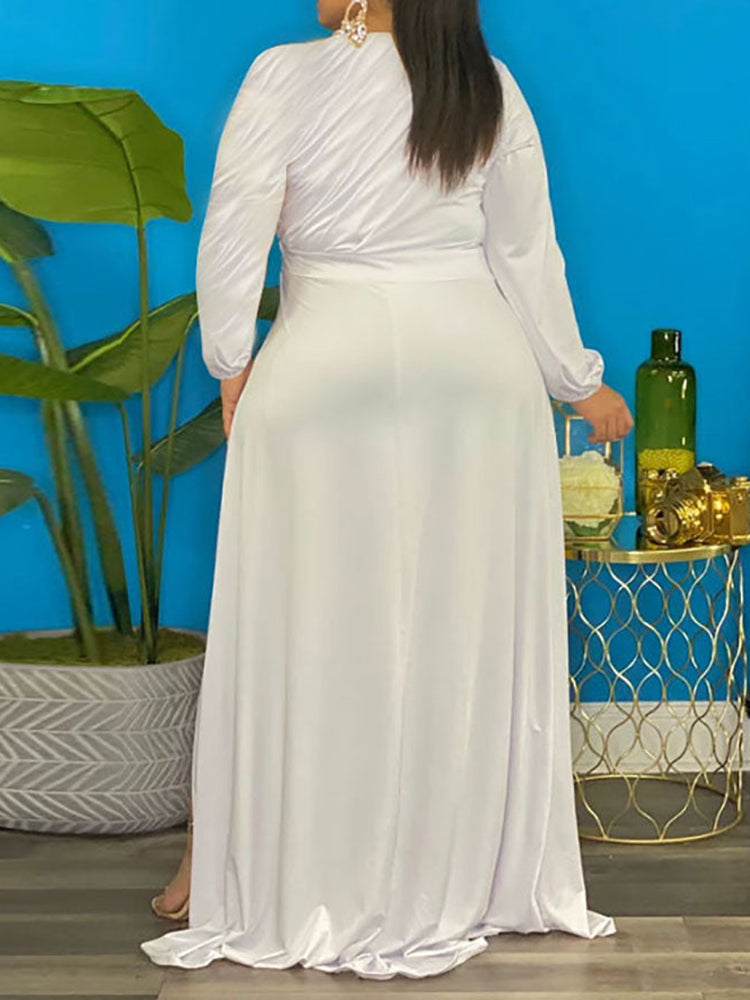 Back view of a woman in a white long-sleeved, high-low hemline dress.