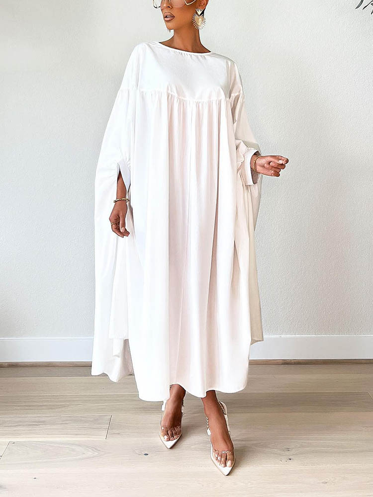 Woman wearing a white maxi dress with flowy sleeves and clear pointed-toe heels