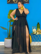 Woman wearing a black sheer maxi dress with high leg slits, front view
