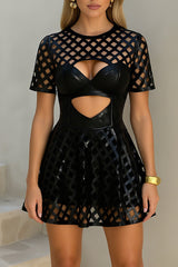 Woman wearing a black faux leather and mesh dress with cut-out details.