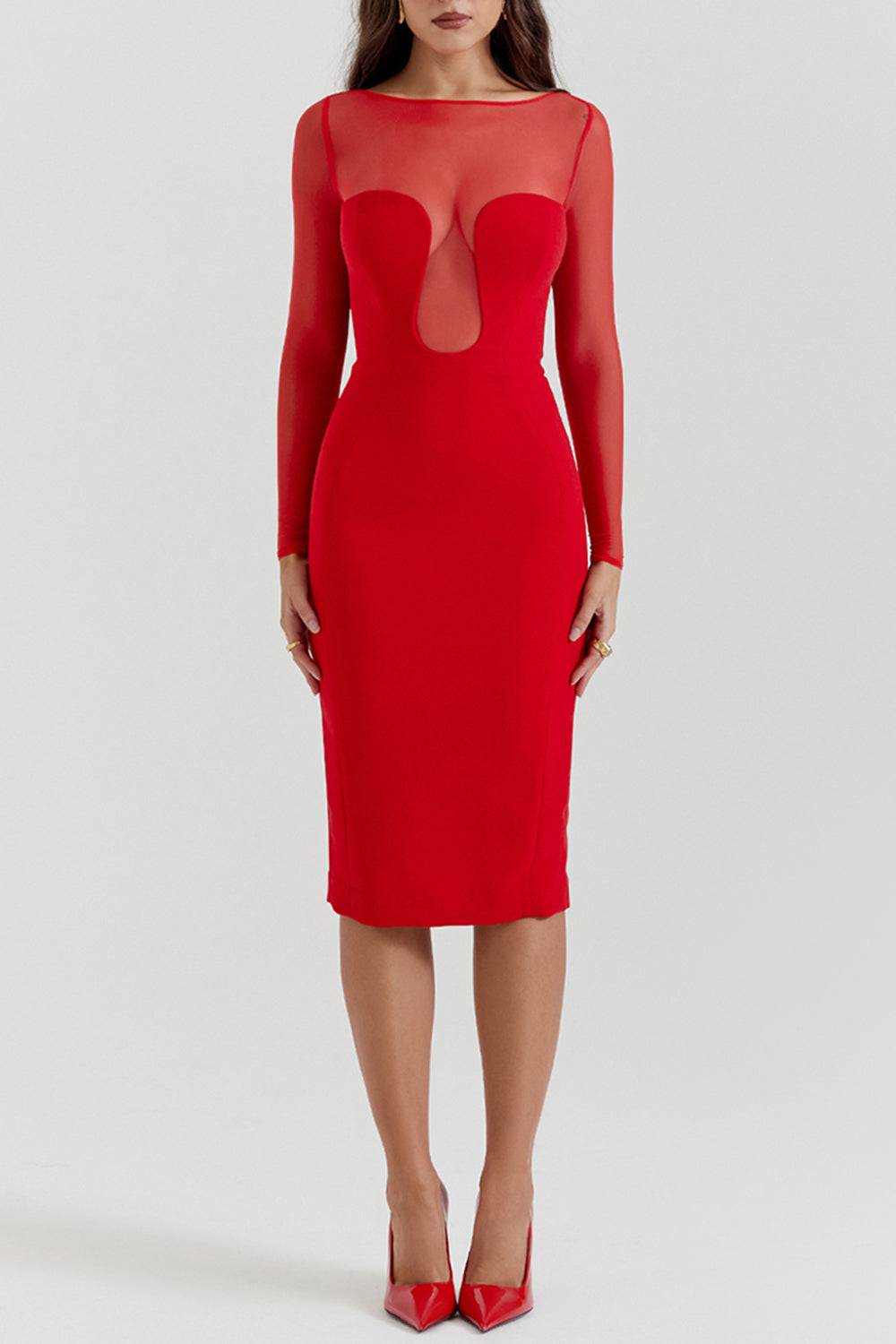 Woman wearing a red sheath dress with sheer illusion neckline and long sleeves, front view