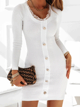 Woman wearing a white long-sleeve ribbed knit mini dress with lace trim and gold buttons, holding a patterned handbag.