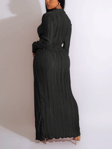 Full-length view of a woman in a red pleated maxi dress, showcasing the wrap-style bodice and high slit.