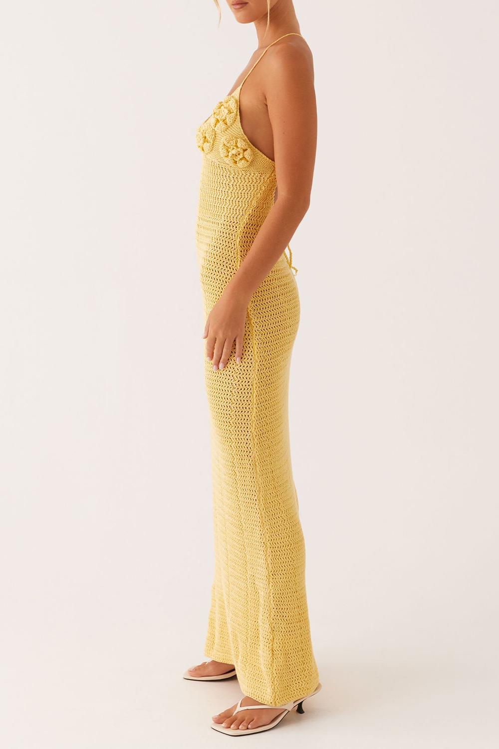 side view of a woman in a yellow crochet knit maxi dress