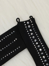 Close-up of black fabric adorned with rows of clear rhinestones of varying sizes.