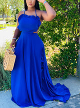 Woman wearing a royal blue two-piece maxi dress with a halter neckline and ruffled trim, holding a straw bag.