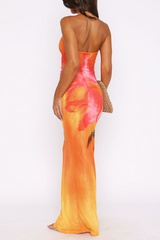 woman wearing an orange and pink floral print halter neck maxi dress with a keyhole cutout, back view