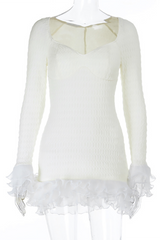 White textured mini dress with long sleeves and ruffled trim displayed on a mannequin.