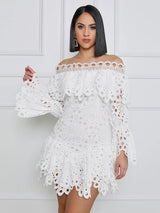 Model wearing a white off-the-shoulder eyelet lace mini dress with bell sleeves and ruffled trim.