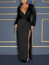 Front view of a woman in a black long-sleeve maxi dress with a deep V-neckline and a high slit.