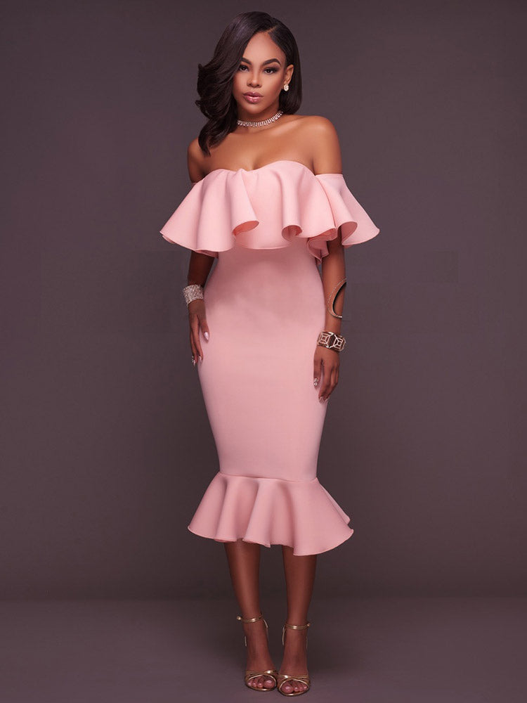 Woman wearing a pink off-the-shoulder ruffle dress and gold heels, front view