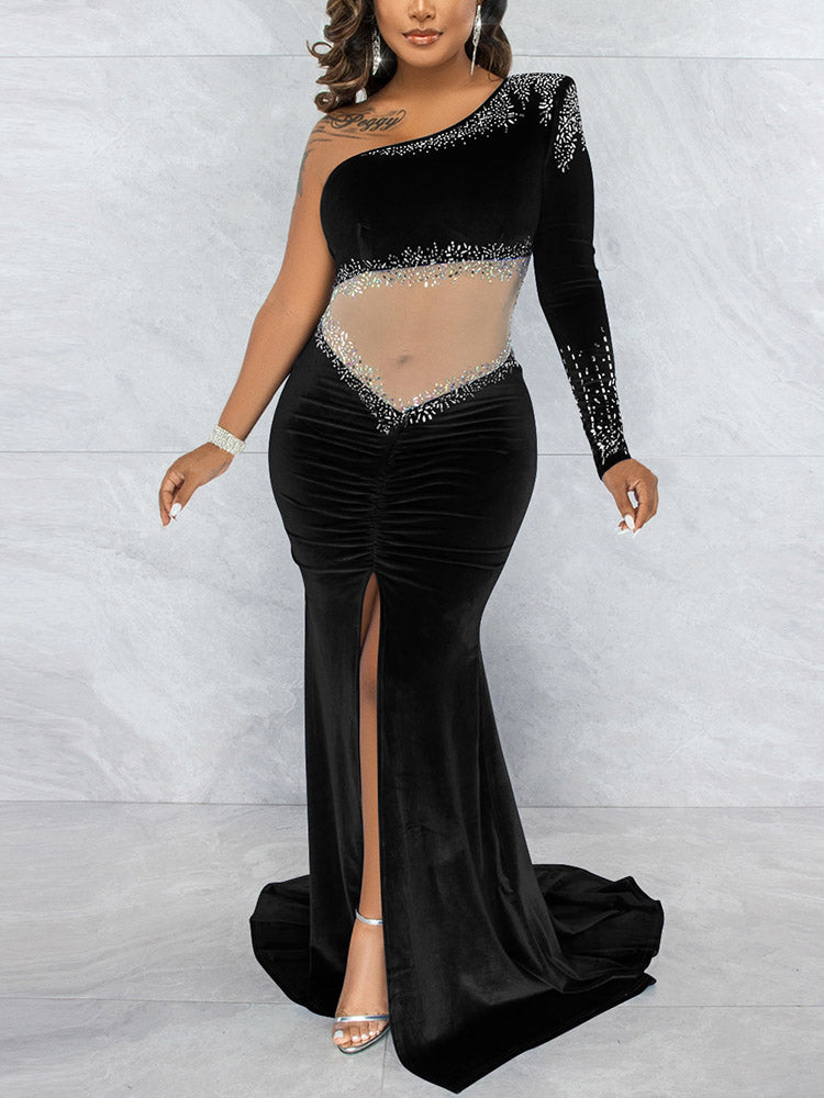 Back view of a woman in a black one-shoulder velvet gown with a train