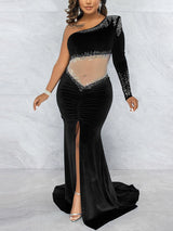 Back view of a woman in a black one-shoulder velvet gown with a train