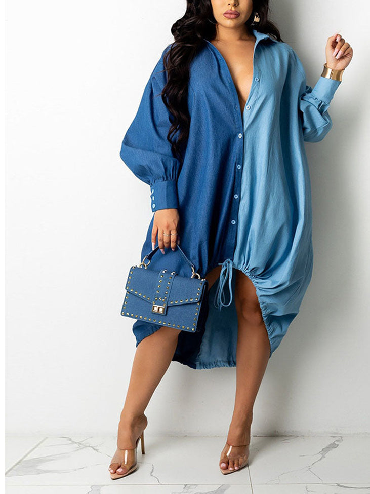 Woman wearing a two-tone blue oversized shirt dress with button-down front and adjustable drawstring hem, holding a studded handbag.