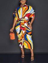 Side view of a woman in a vibrant abstract print shirt dress.