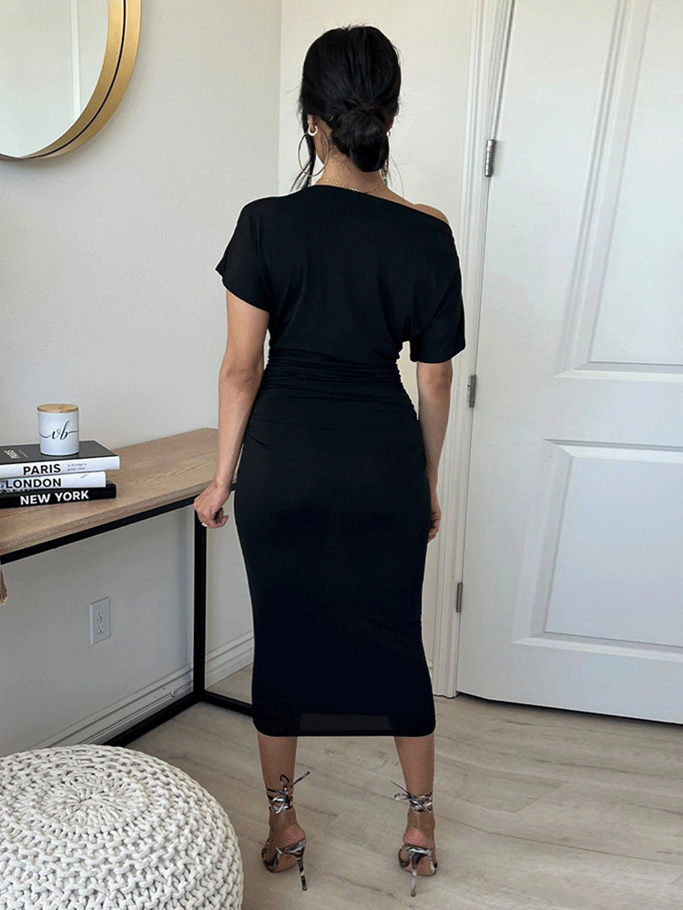 back view of a woman in a black one-shoulder ruched midi dress