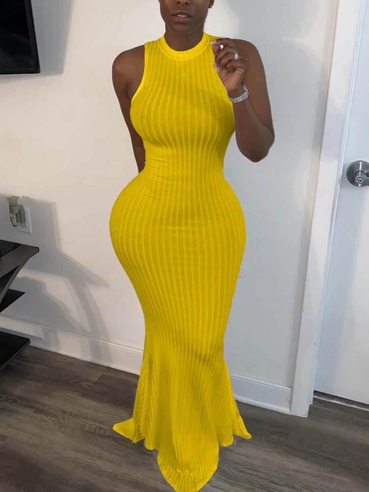 Woman wearing a yellow sleeveless ribbed knit maxi dress with a mermaid hem and mock neckline.
