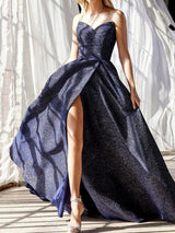 Model wearing a navy blue sparkly strapless ball gown with a high slit, standing in natural light.