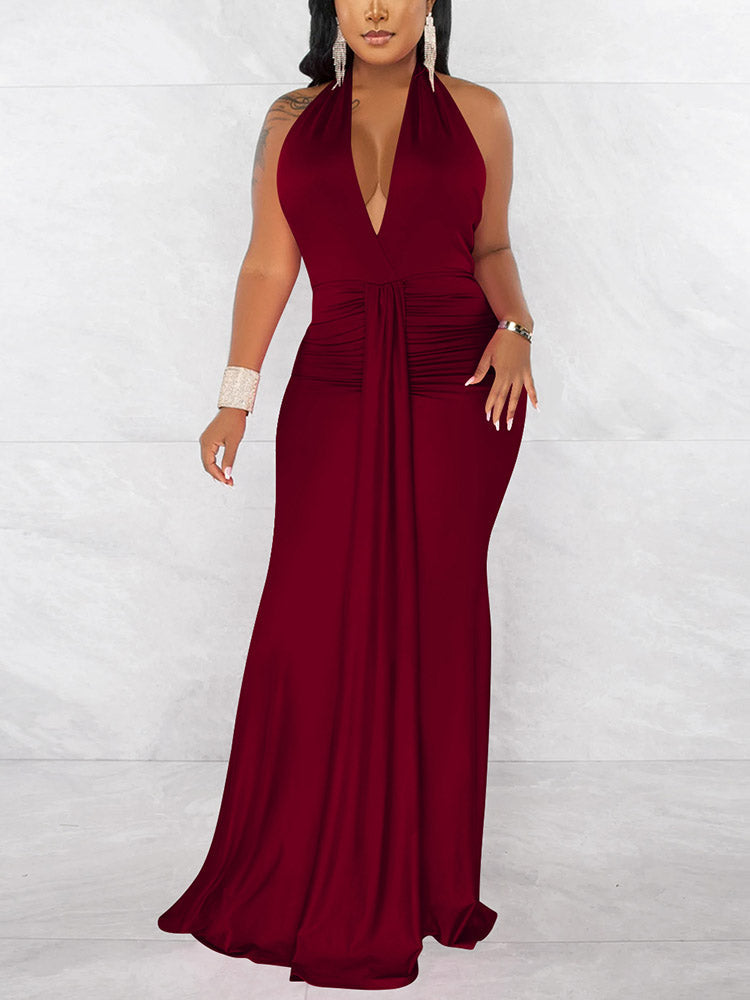 Woman wearing a long deep red halter neck dress with a deep V-neck and ruched waist