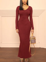 Woman wearing a long-sleeved, ribbed knit maxi dress in burgundy, front view.