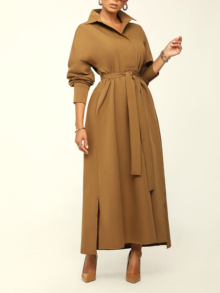 Woman wearing a long brown collared dress with a belted waist and brown high heels.