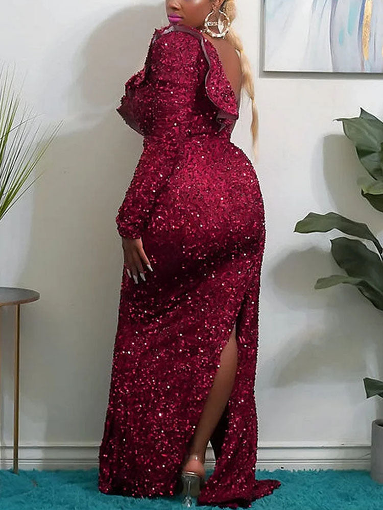 Back view of a woman in a floor-length, one-shoulder, sequined gown with a high slit in red.