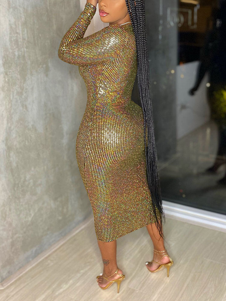 Side view of a woman in a gold sequined long-sleeve midi dress.
