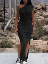 Woman wearing a black one-shoulder, draped maxi dress with a high slit and sneakers.