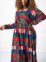 Woman wearing a belted plaid maxi dress with long sleeves
