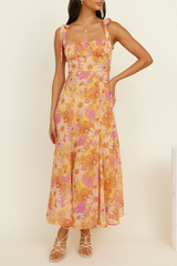 front view of a woman in a yellow floral midi dress with tie shoulder straps