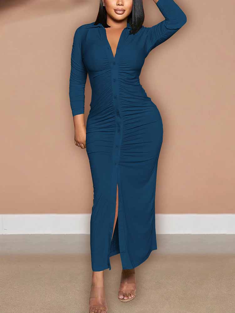 Woman modeling a teal ruched maxi dress with a collared v-neck and long sleeves, with a front slit.
