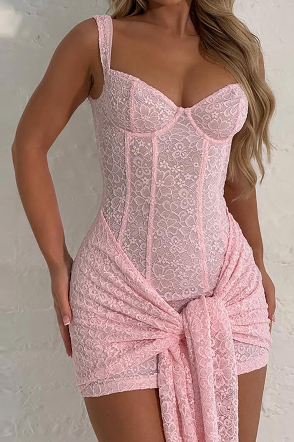 Close-up of a pink lace corset dress with a draped skirt