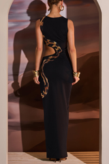 Back view of a woman in a black sleeveless maxi dress with a high neckline and cut-out detailing along the sides, showcasing the snake print.