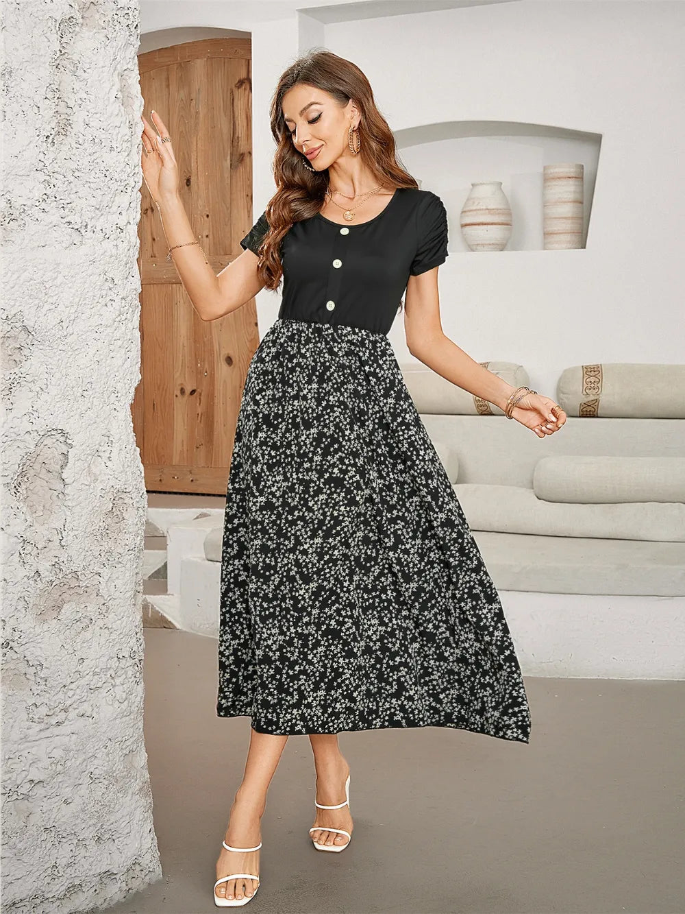 Woman posing in a black and floral print midi dress.