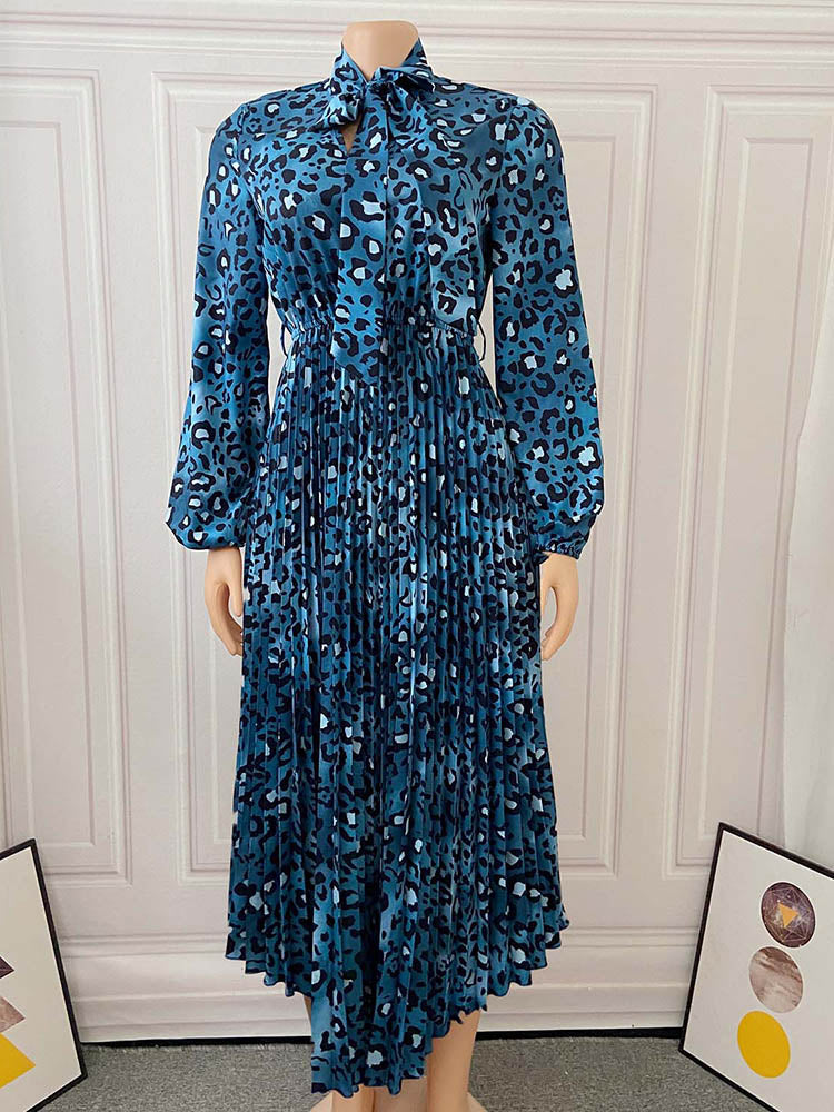 Mannequin displaying a blue leopard print midi dress with a bow neckline and pleated skirt.
