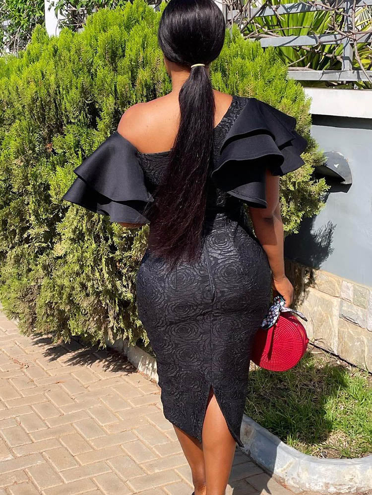 Back view of a woman in a black one-shoulder midi dress with ruffle sleeves and a rose jacquard pattern.