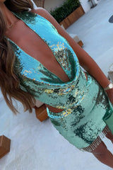 woman modeling a sparkly mint green sequined halter dress with a deep V-neck