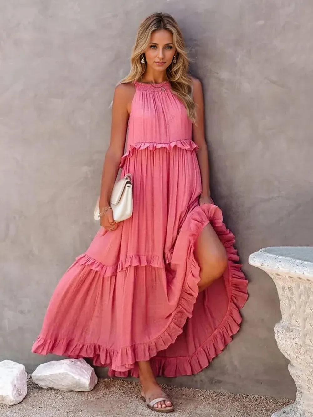 woman wearing a pink tiered ruffle maxi dress with a halter neckline and smocked detail