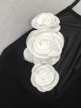 close-up of white floral embellishments on the bodice of a black halter dress