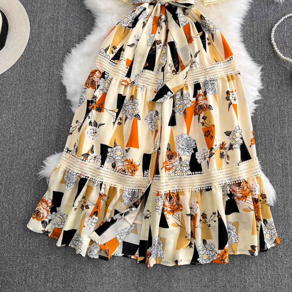 Close-up of the tiered skirt of a floral and geometric print maxi dress.