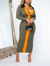 Woman wearing a long-sleeved, bodycon midi dress with olive green and orange color-blocking, standing in front of a mirror.