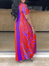 Side view of a woman wearing an orange and purple color block maxi dress with an abstract graphic print.